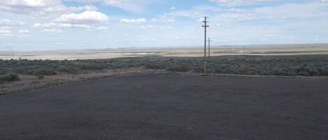 A barren landscape with sparse vegetation and a clear sky.