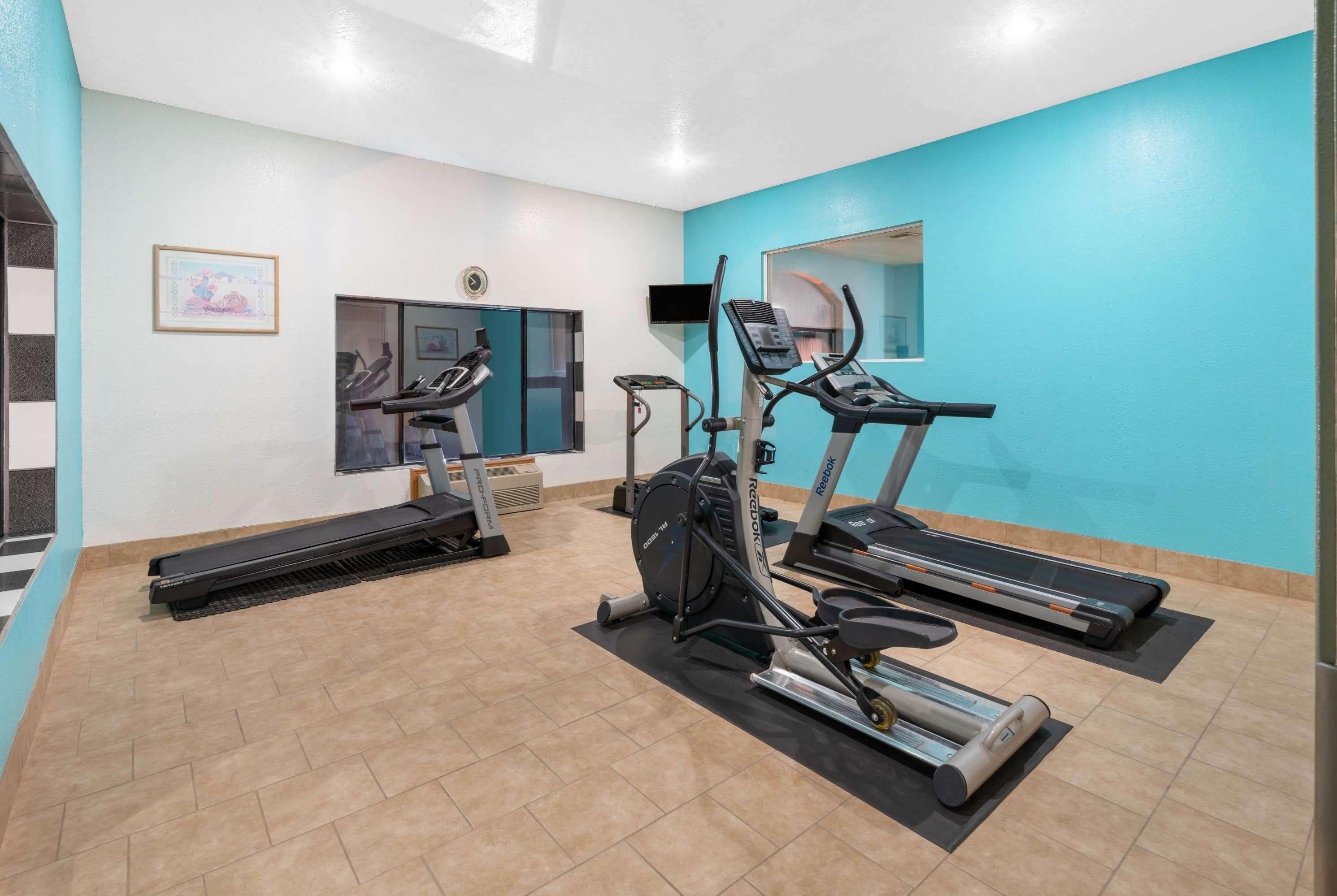 A gym with treadmills, an elliptical, and a stationary bike.