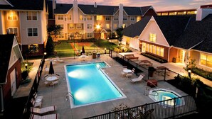 Un immeuble résidentiel doté d’une piscine, d’un espace extérieur aménagé et d’une cour bien éclairée.