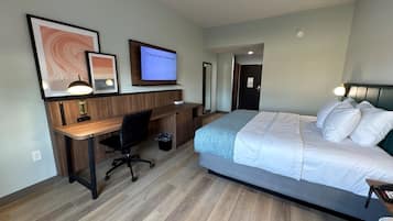 A hotel room with a bed, desk, chair, and a TV displaying 'Channel not authorized'.