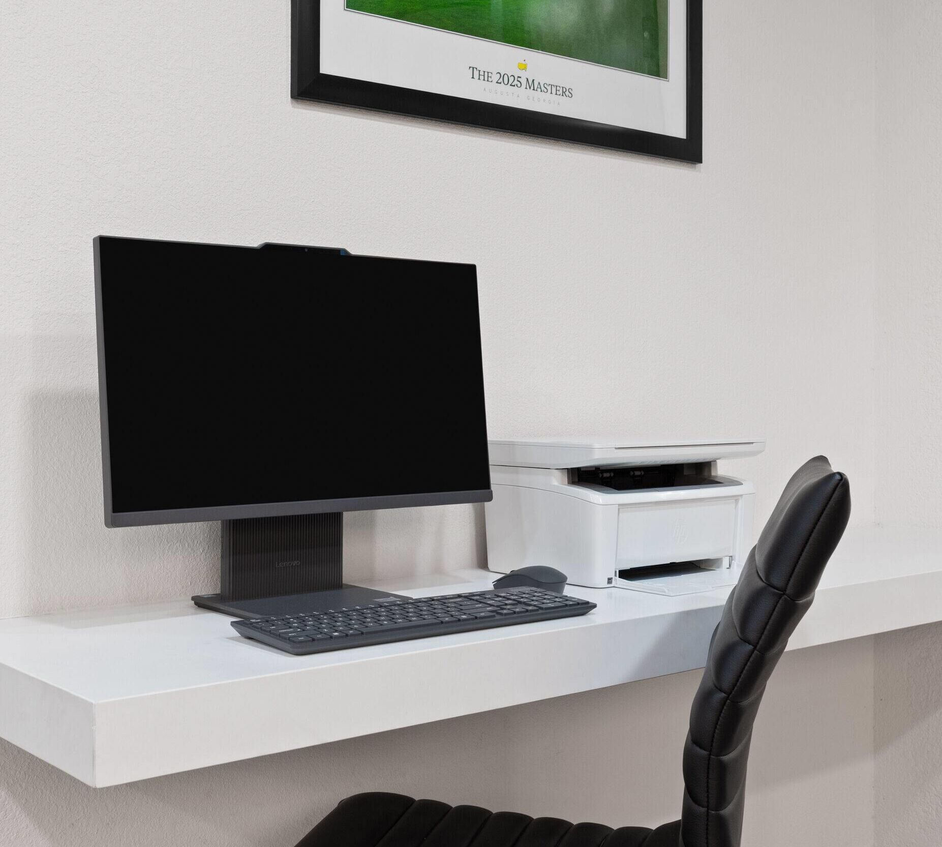 A modern office setup with a desktop computer, keyboard, and printer on a white desk.