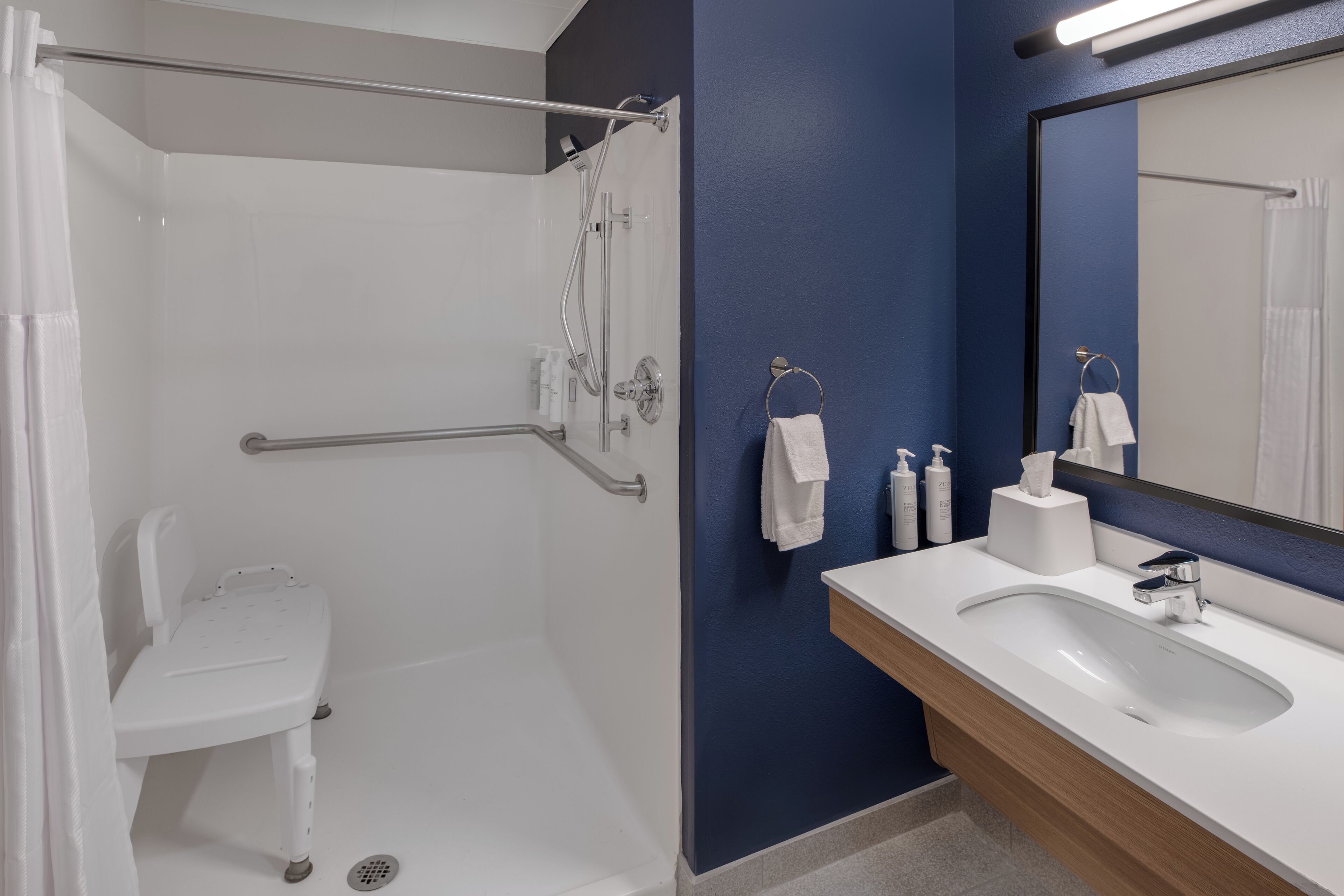 A modern bathroom with a shower, toilet, and sink.