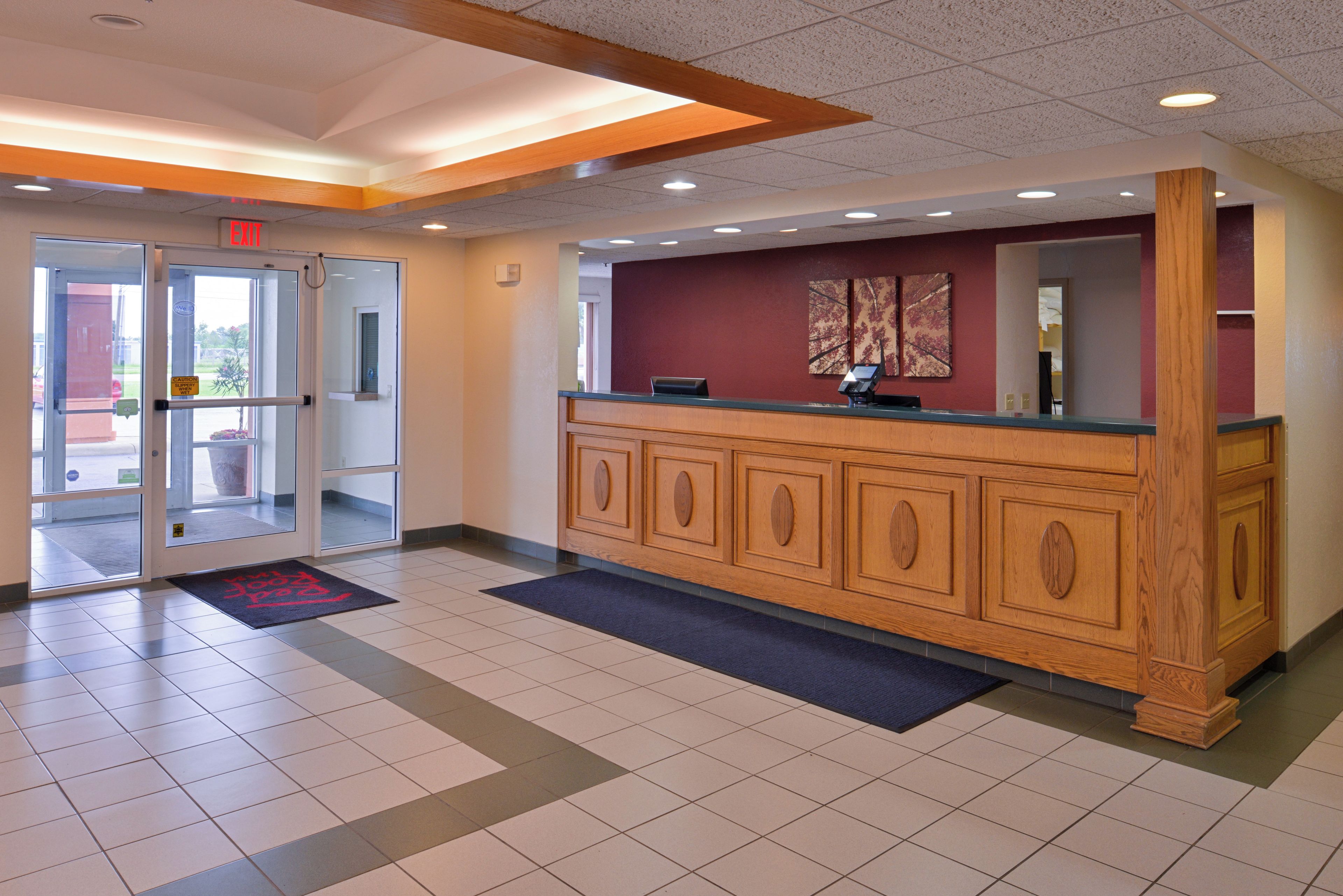 A reception area with a glass door entrance, a reception desk, and a check-in counter.