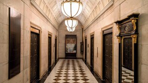 A hallway with a checkered floor, double doors, and a large chandelier. - The Ritz-Carlton, Philadelphia (Philadelphia)