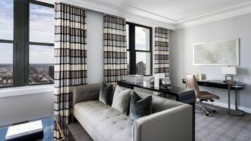 Une chambre d’hôtel moderne dotée d’une grande fenêtre, d’un canapé, d’un bureau et d’une chaise.