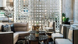 A modern lobby with a decorative glass wall, comfortable seating, and a chandelier. - The Ritz-Carlton, Philadelphia (Philadelphia)