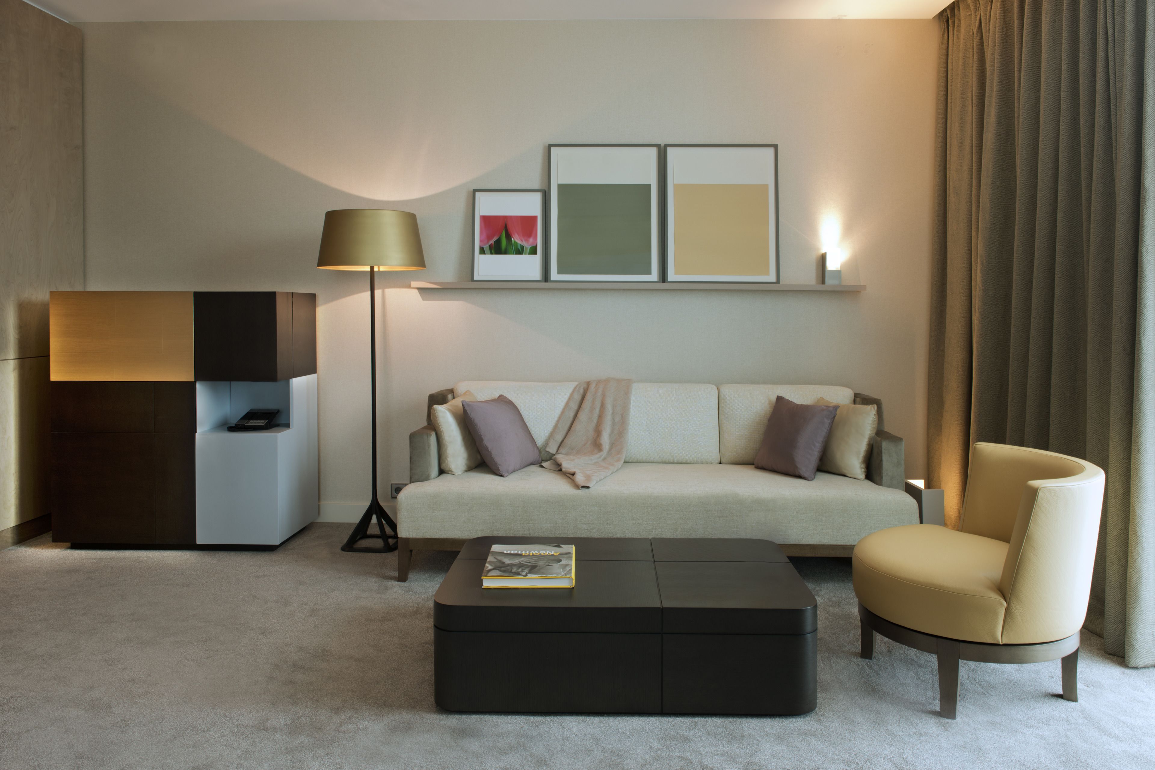 Ein modernes Wohnzimmer mit einer Couch, einem Sessel, einem Couchtisch und einer Stehlampe.