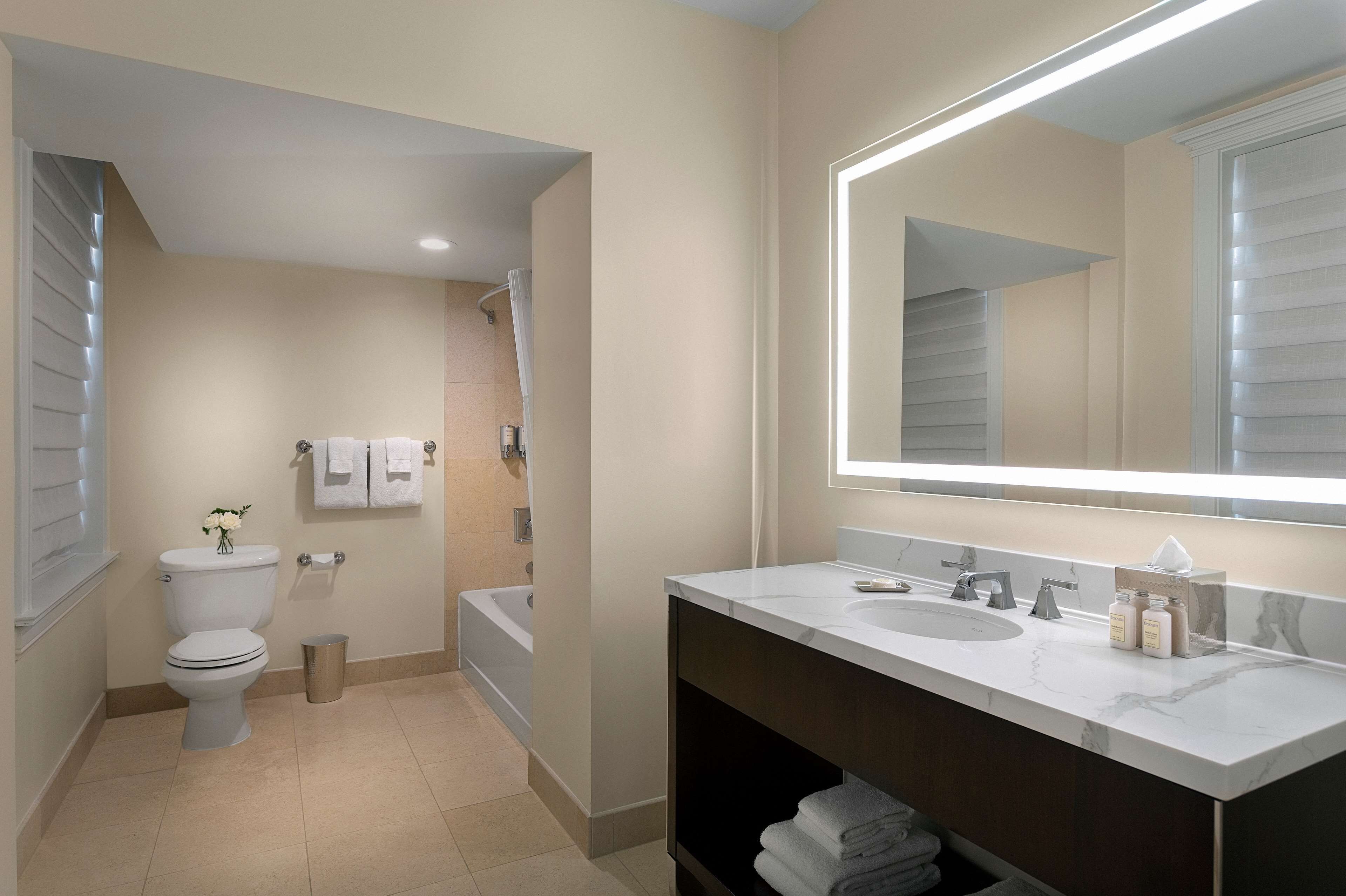 A modern bathroom with a toilet, sink, and bathtub.