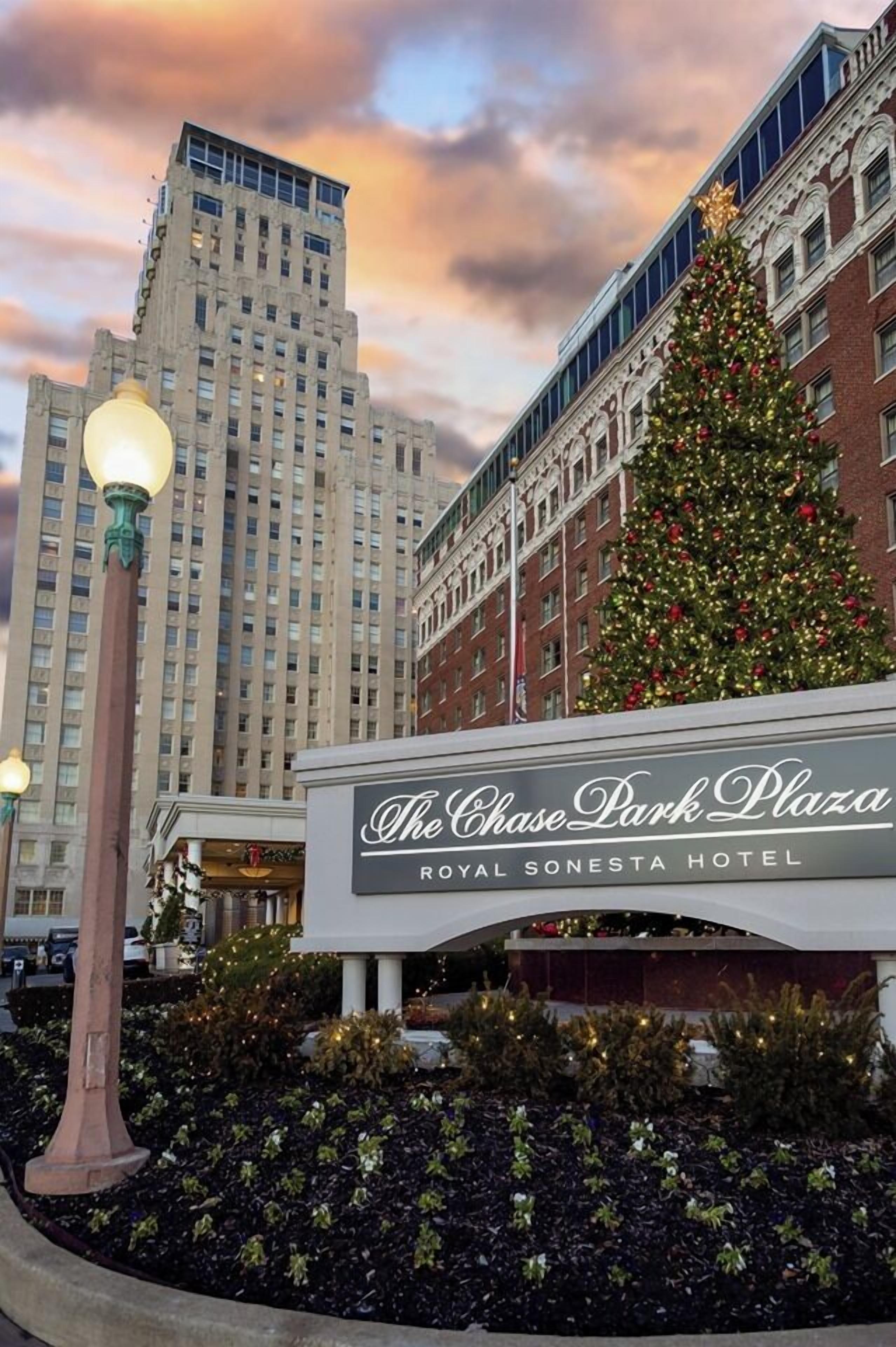 A hotel sign with a Christmas tree and a lamp post.