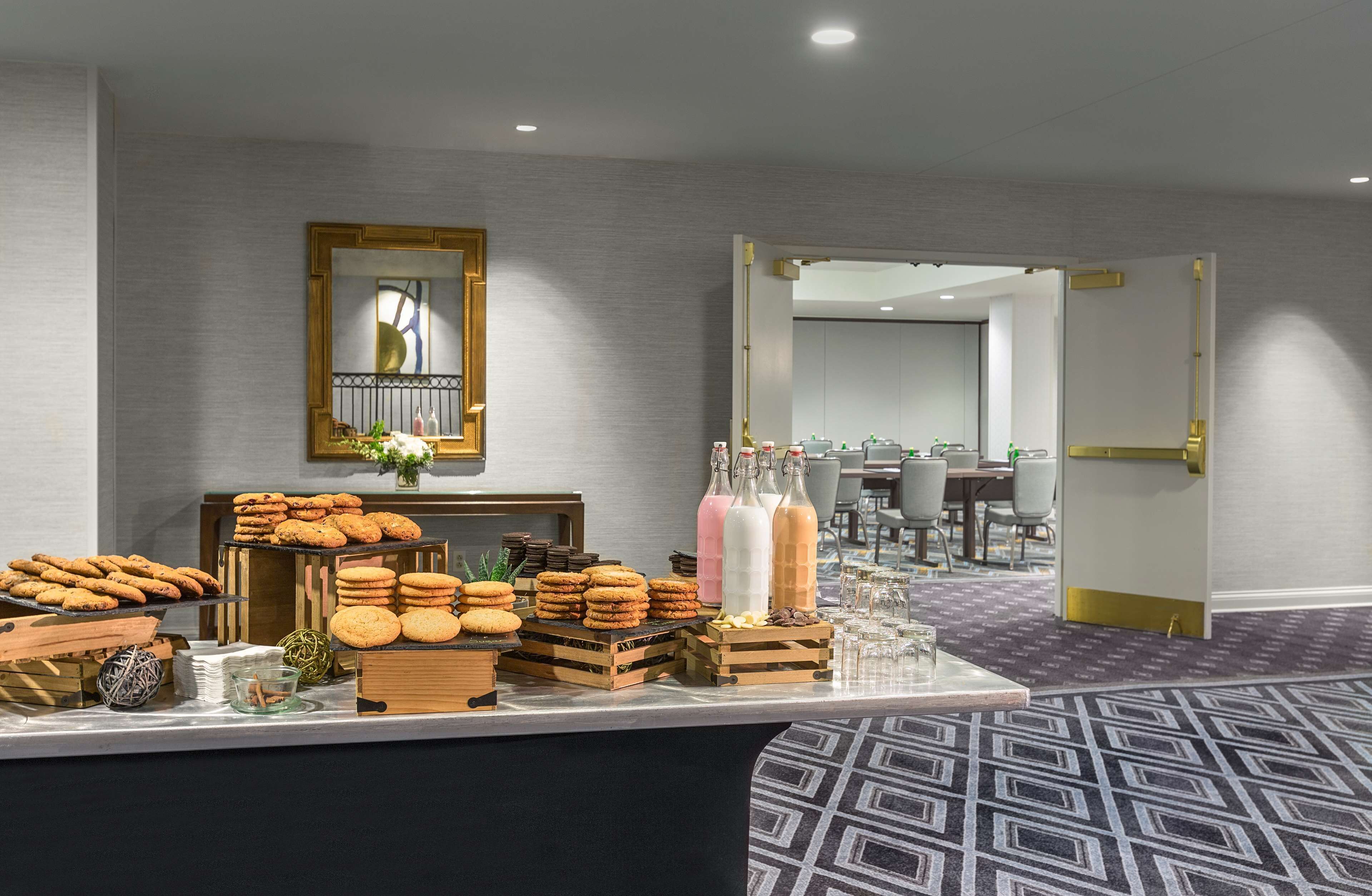 A buffet area with various food items and beverages, a mirror, and a patterned carpet.