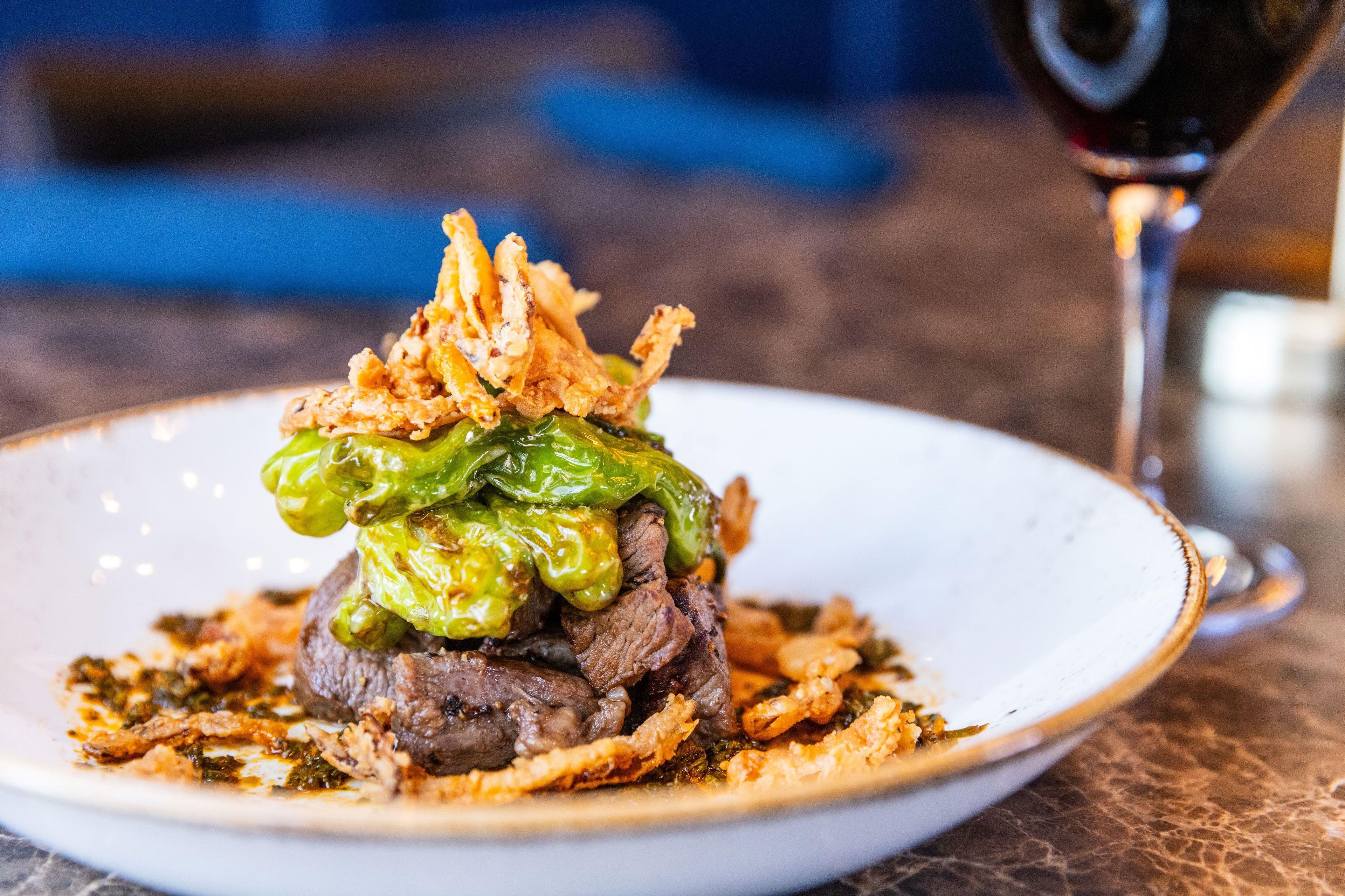 A plate of food with a glass of red wine.
