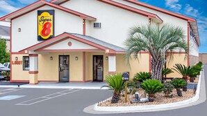 Un hotel Super 8 con fachada color beige, detalles en rojo y un letrero que dice 'Lobby'.