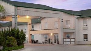 A multi-story hotel with a green roof and beige exterior walls. - Super 8 by Wyndham Morden (Morden)