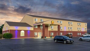 A motel with a two-story structure, a parking lot, and several cars parked in front. - Super 8 by Wyndham Ottawa (Ottawa)