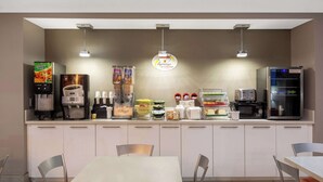 A modern breakfast bar with coffee machines, a microwave, and a refrigerator. - Super 8 by Wyndham Ottawa (Ottawa)