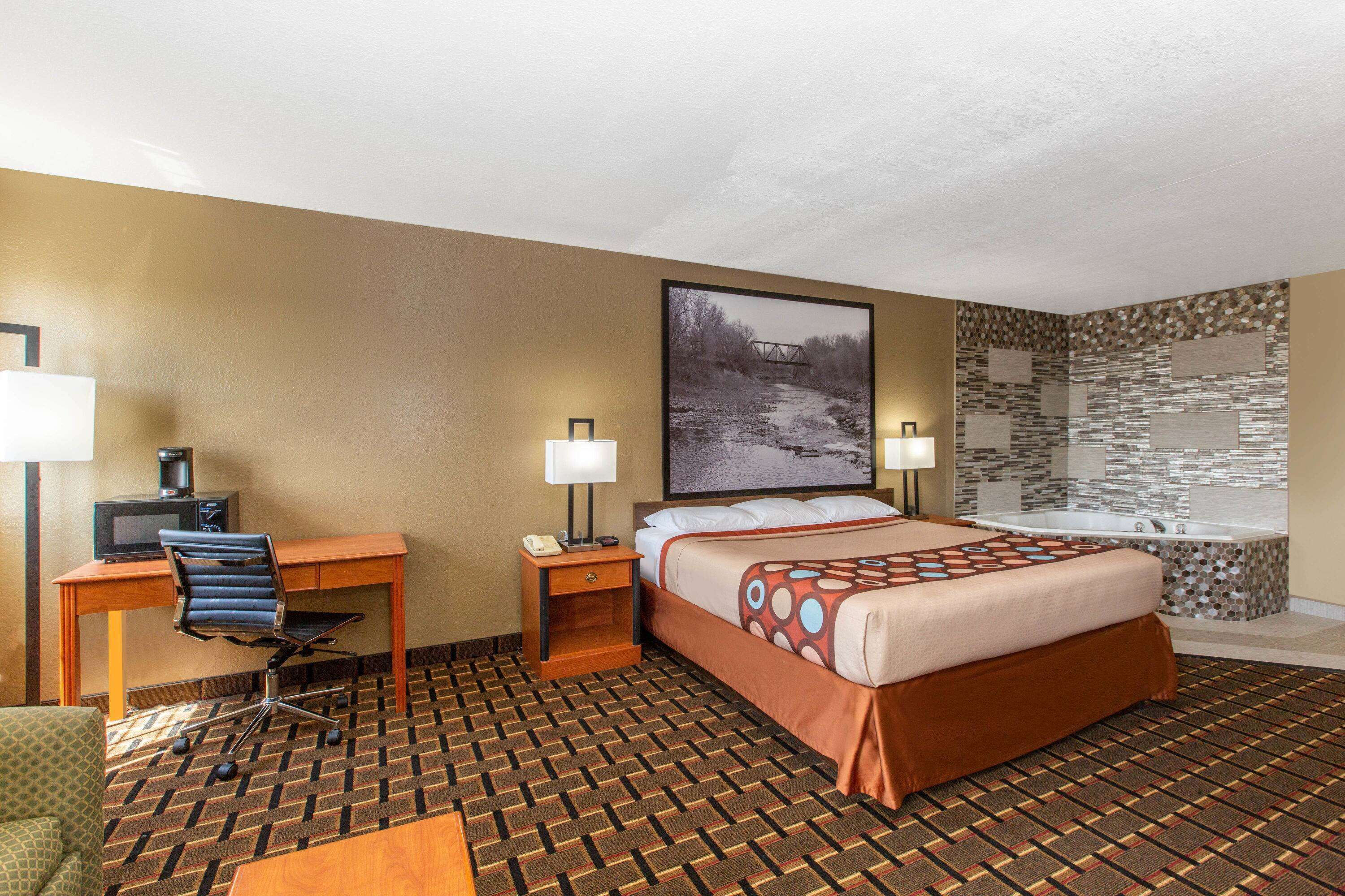 Ein Hotelzimmer mit Bett, Schreibtisch, Stuhl und Badewanne.