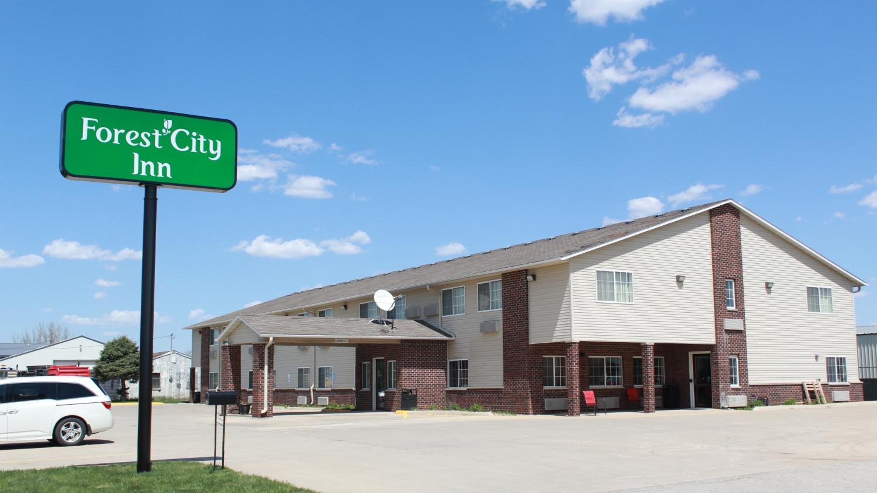 A two-story building with a sign reading "Forest City Inn" in front.