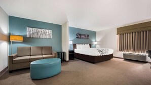 A hotel room with a bed, a sofa, a coffee table, a desk, and a lamp. - Sleep Inn & Suites Cullman I-65 exit 310 (Cullman)