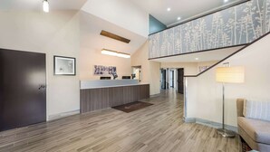 A modern reception area with a wooden floor, a reception desk, a staircase with a tree-patterned railing, and a floor lamp. - Sleep Inn & Suites Cullman I-65 exit 310 (Cullman)