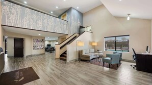 A spacious living area with a staircase, a sofa, a coffee table, and a desk with a computer. - Sleep Inn & Suites Cullman I-65 exit 310 (Cullman)
