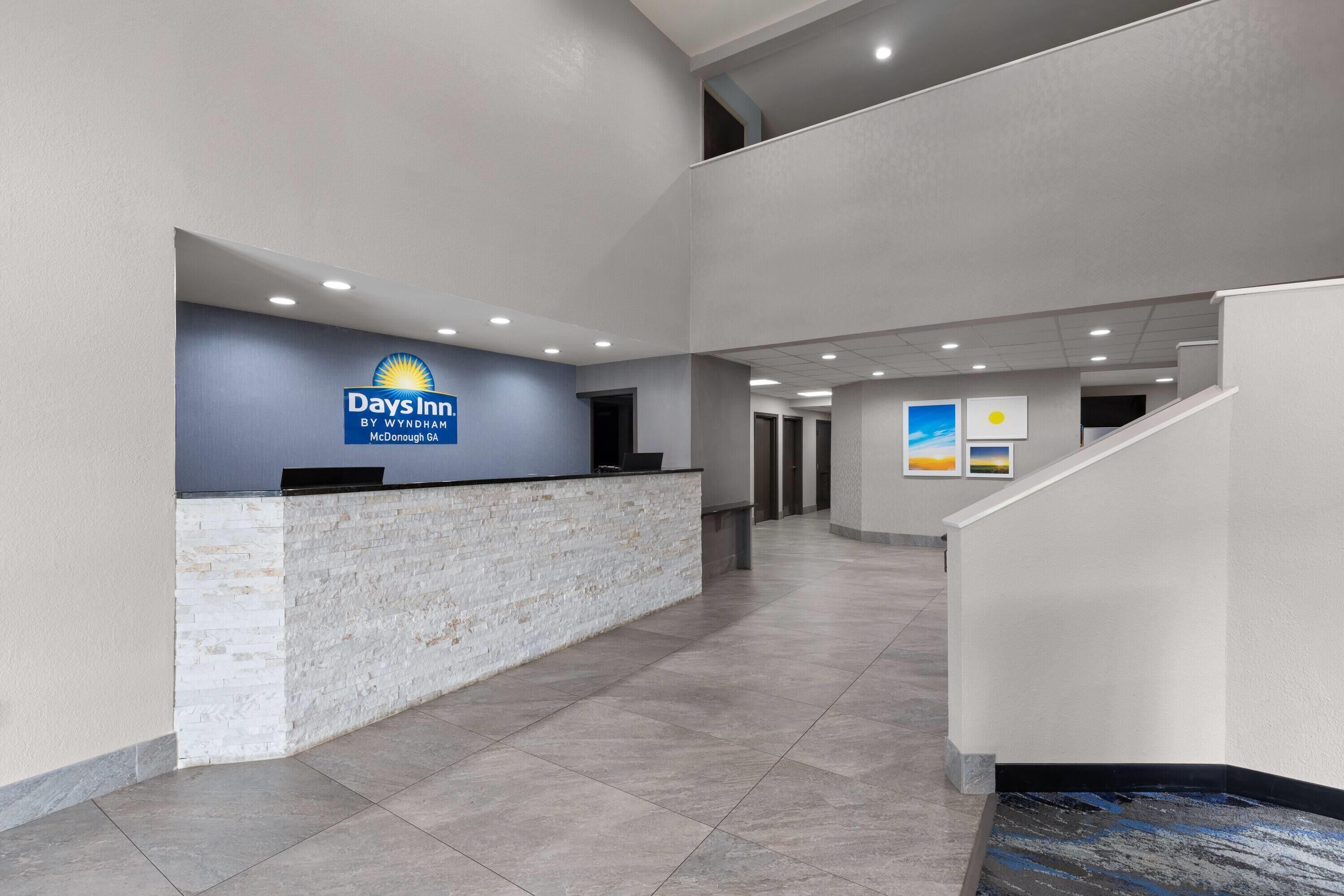 A reception area with a stone counter, a sign for Days Inn, and a staircase.