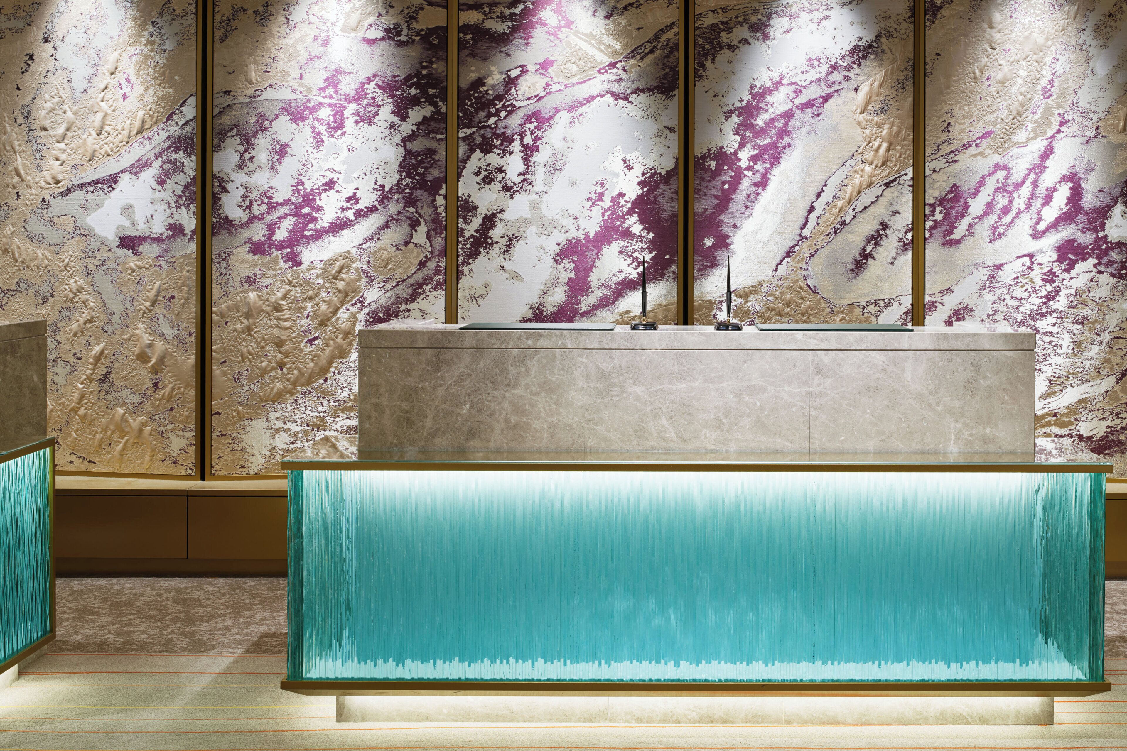 A modern interior with a marble wall, a teal accent wall, and a minimalist design.