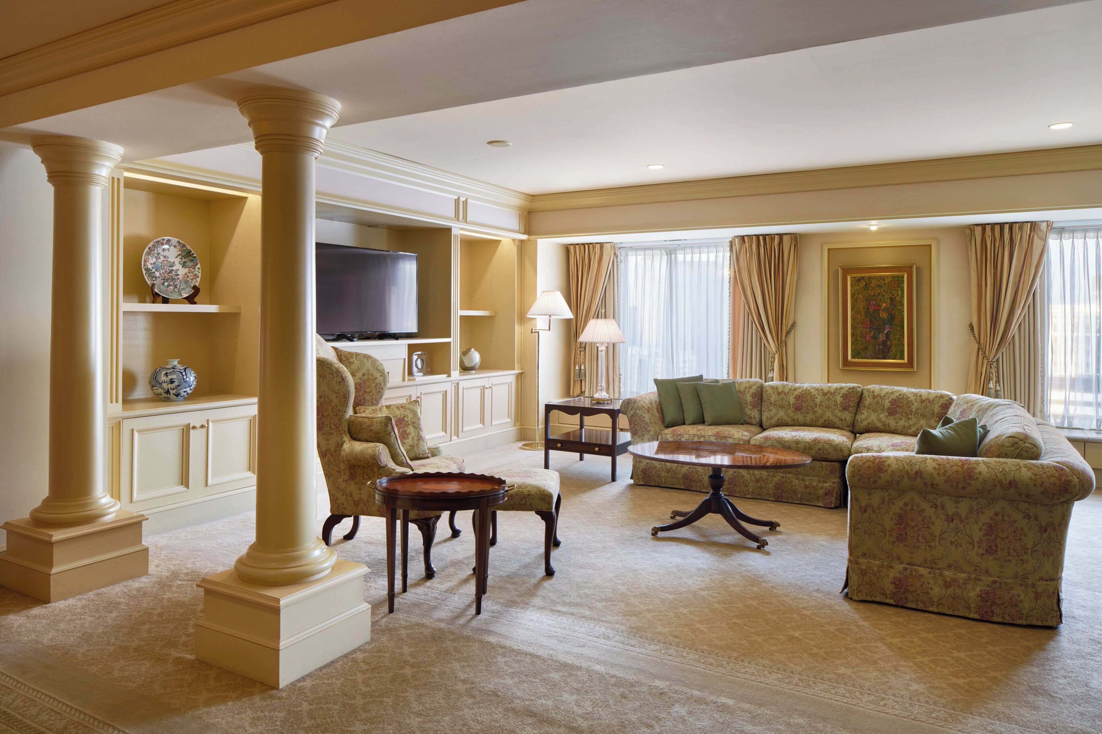 A spacious living room with a large sectional sofa, a television, and a decorative lamp.