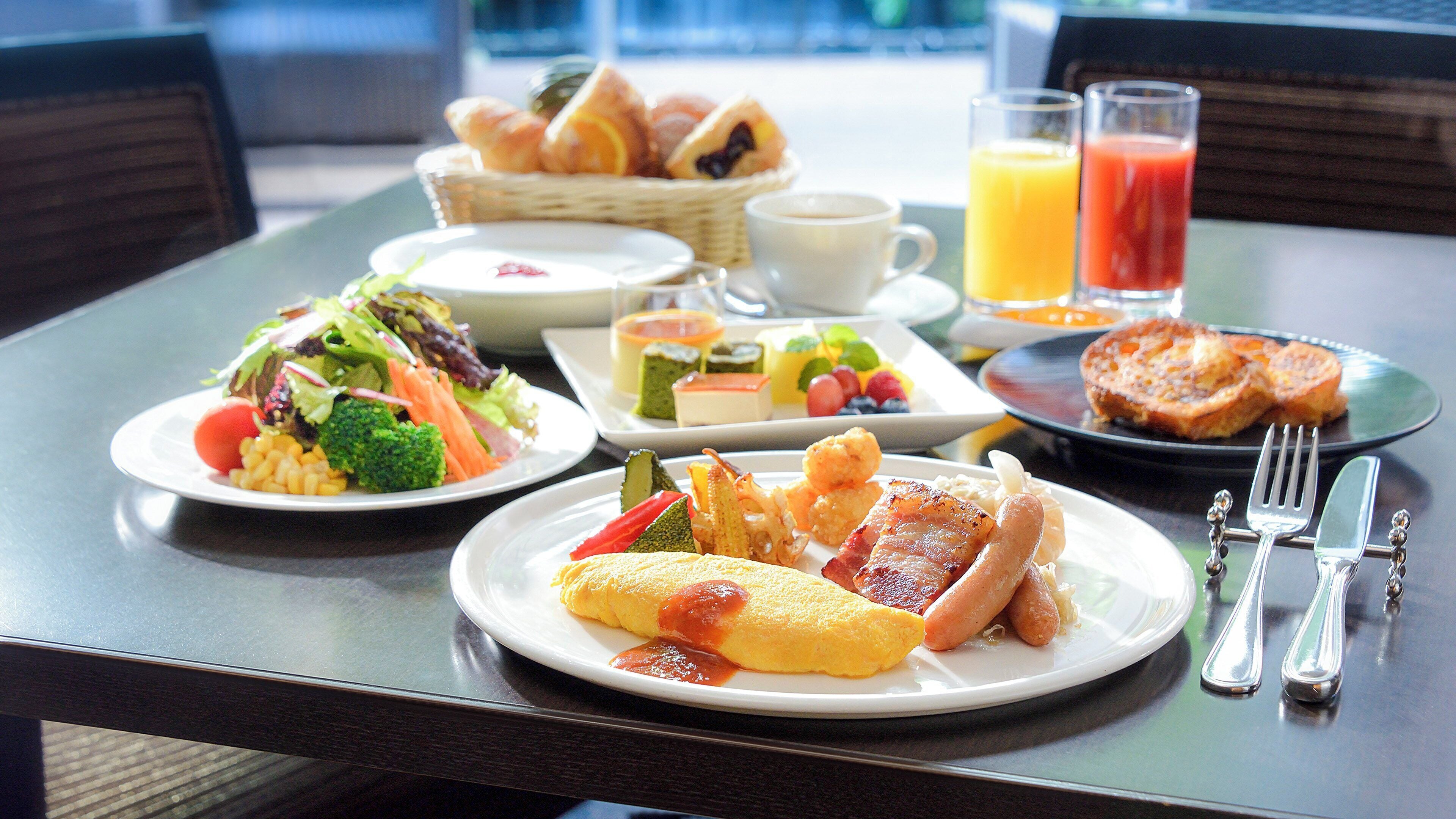 A breakfast buffet with various dishes, including eggs, bacon, and salads.