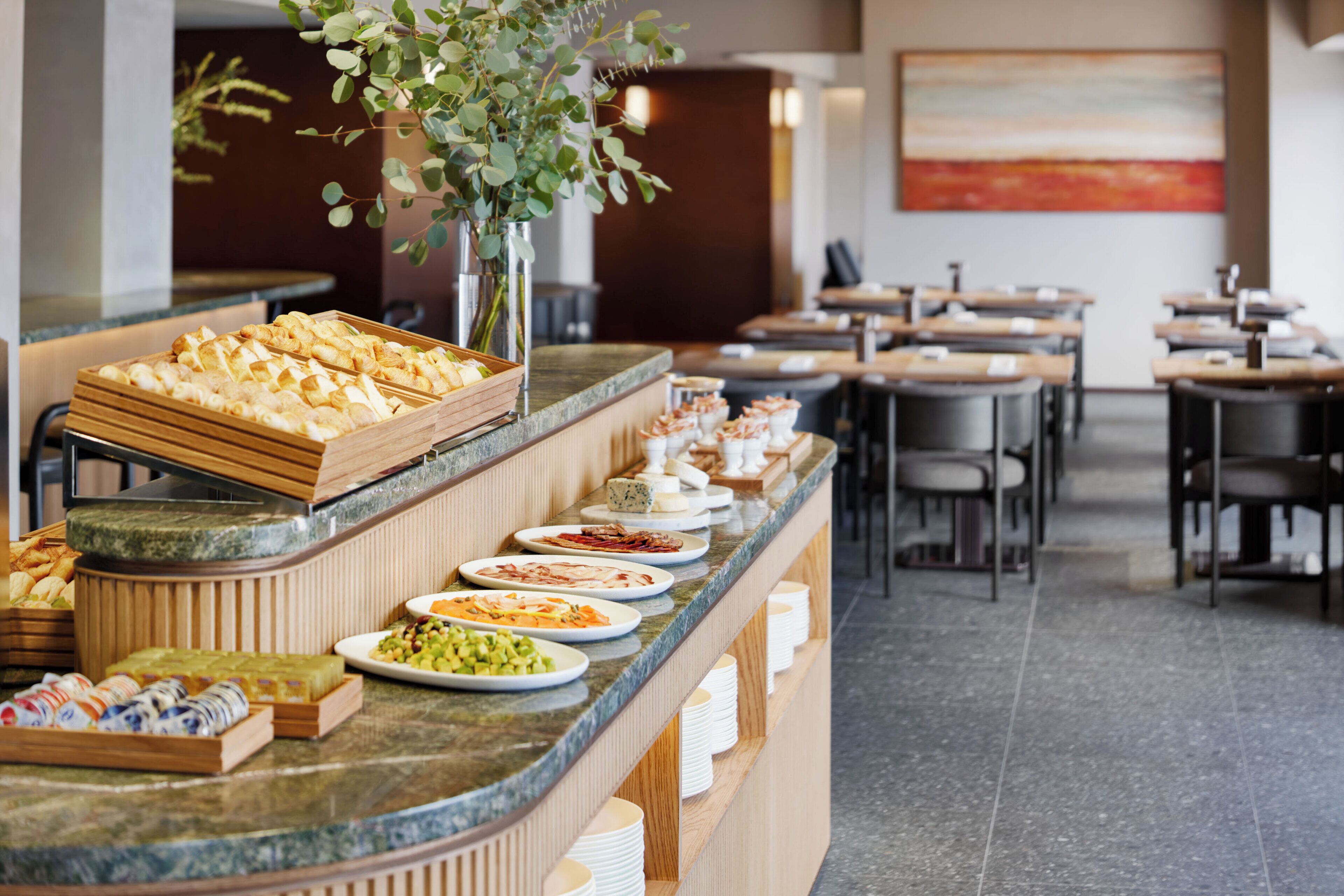 A buffet area with various food items and a seating area with tables and chairs.