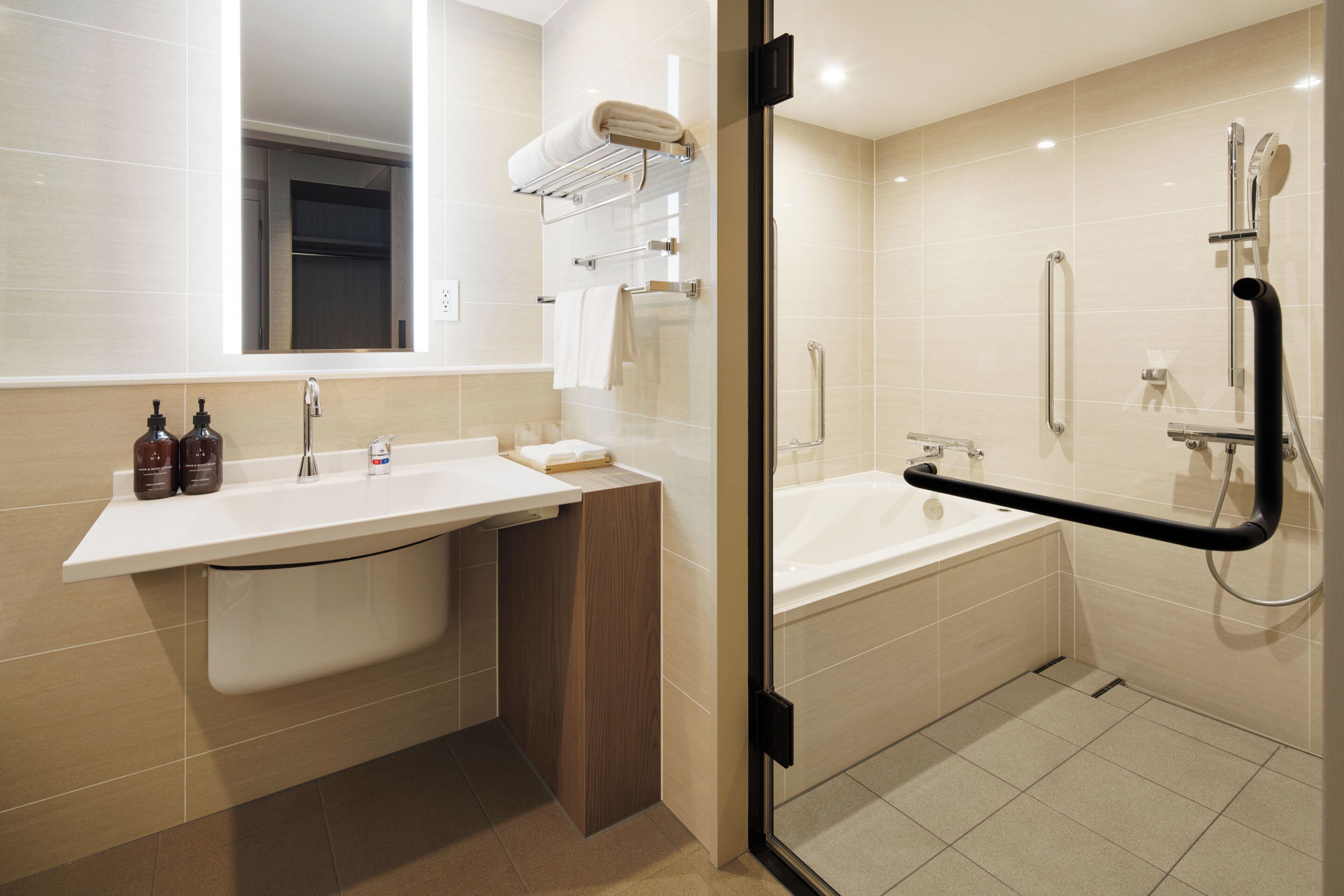 A modern bathroom with a white sink, mirror, and bathtub.