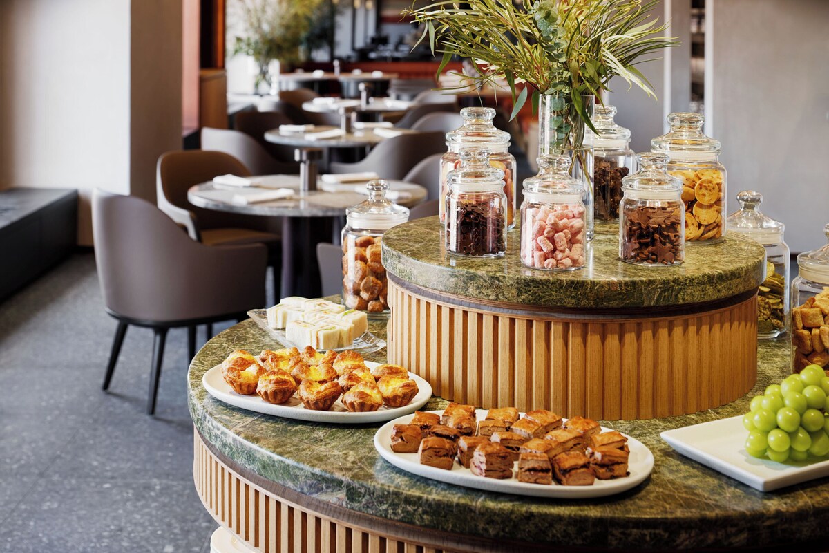 A buffet setup with various food items and condiments.
