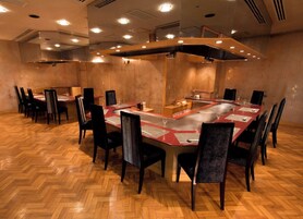 A conference room with a long table, multiple chairs, and a modern ceiling design.