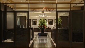 A hotel lobby with a central floral arrangement, a chandelier, and a sign reading "DINING SERIO". - RIHGA Royal Hotel Tokyo (Tokyo)
