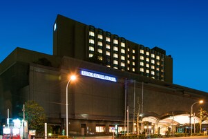 The exterior of the RIHGA ROYAL HOTEL with a prominent sign, large windows, and a modern architectural design.