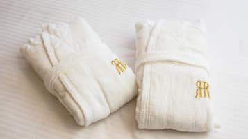 Two white towels with embroidered initials on a textured surface.