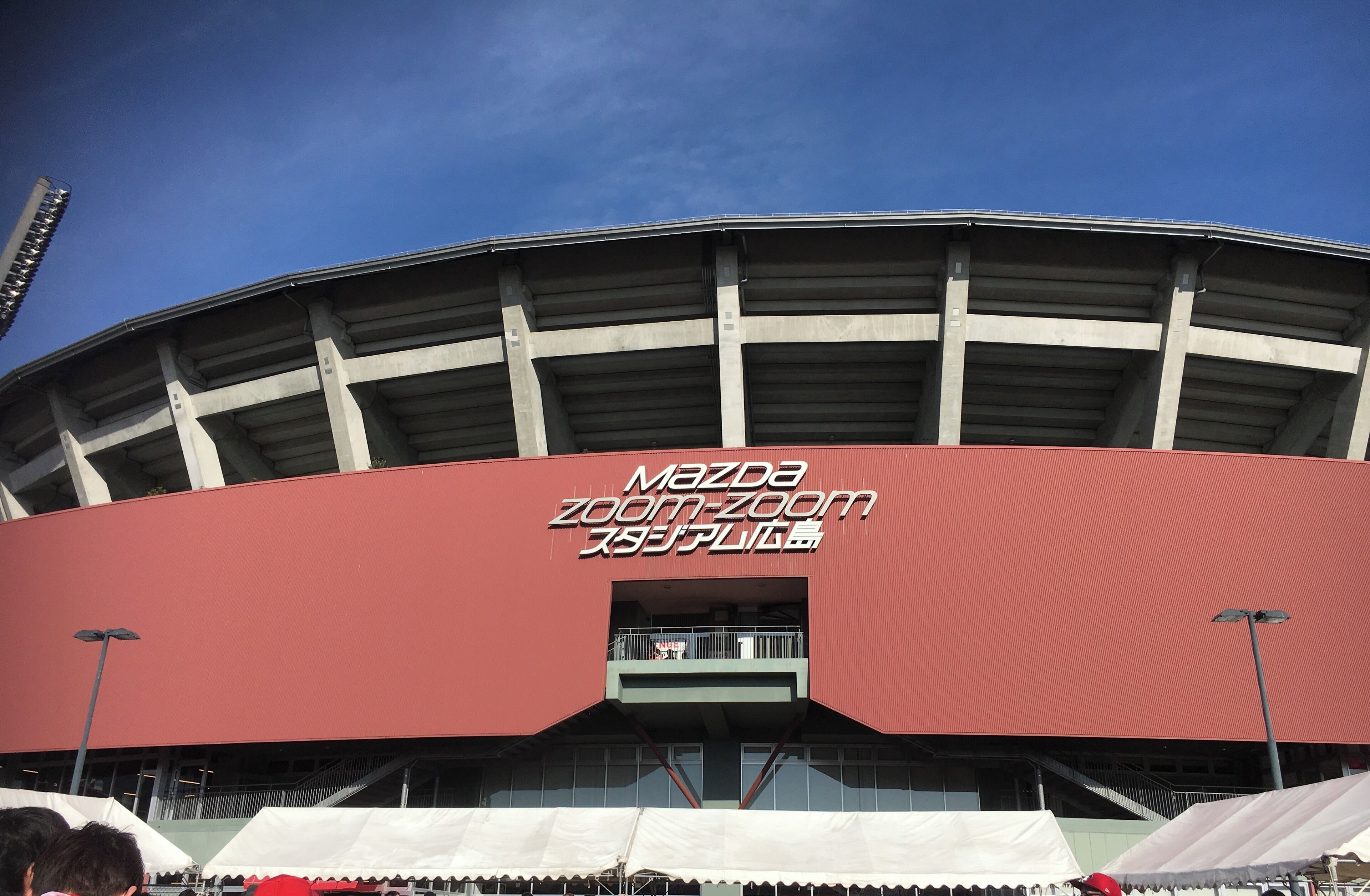 Ein Stadion mit einem großen roten Dach und einem Schild mit der Aufschrift 'Mazda Zoom-Zoom'.