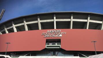 Ein Stadion mit einem großen roten Dach und einem Schild mit der Aufschrift 'Mazda Zoom-Zoom'.