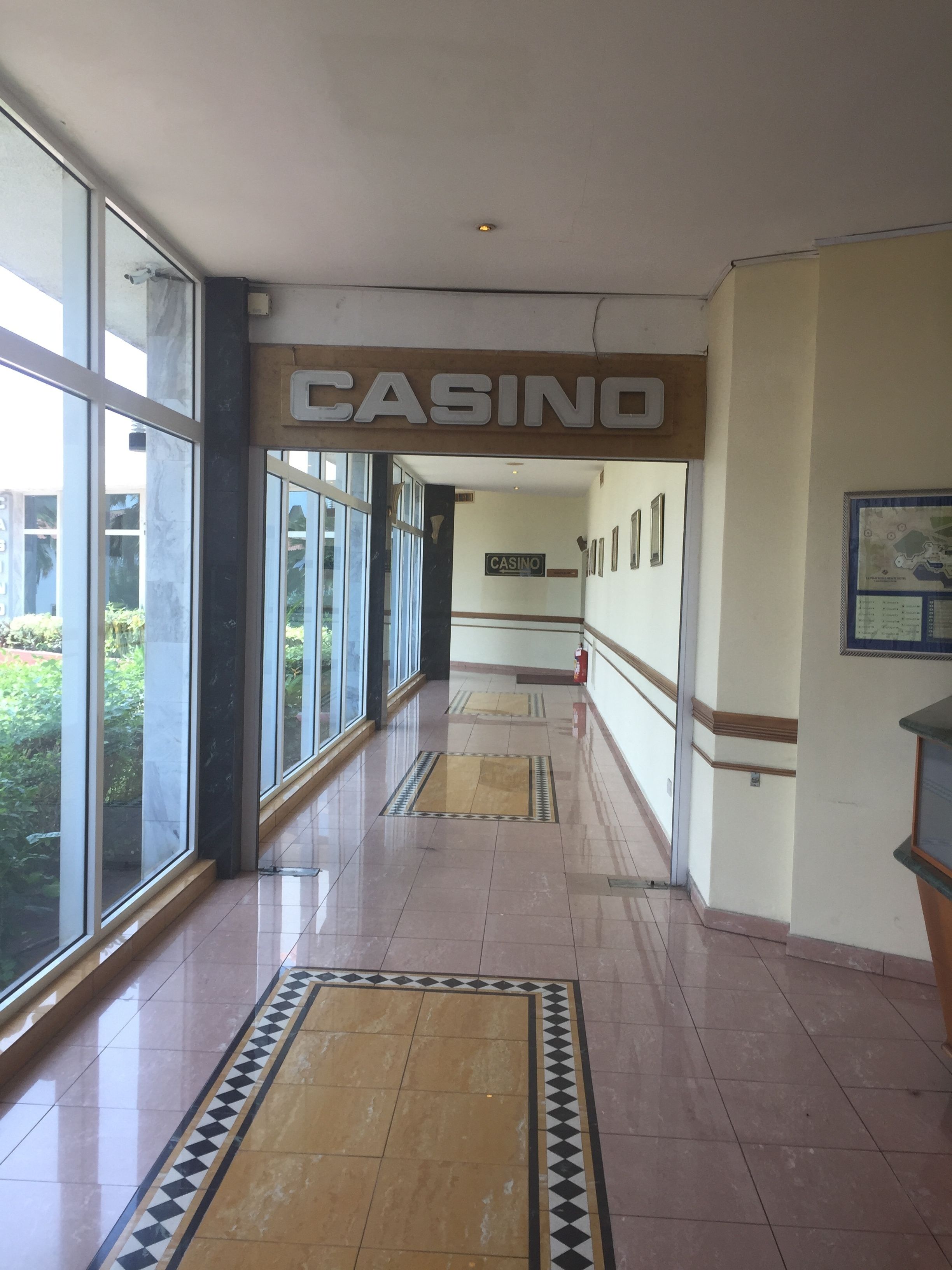 A long, well-lit hallway with a 'CASINO' sign overhead, leading to a room with a map on the wall.