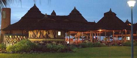 A traditional building with multiple pointed roofs, a covered porch, and a well-maintained lawn.