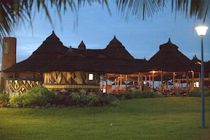 A traditional building with multiple pointed roofs, a covered porch, and a well-maintained lawn.