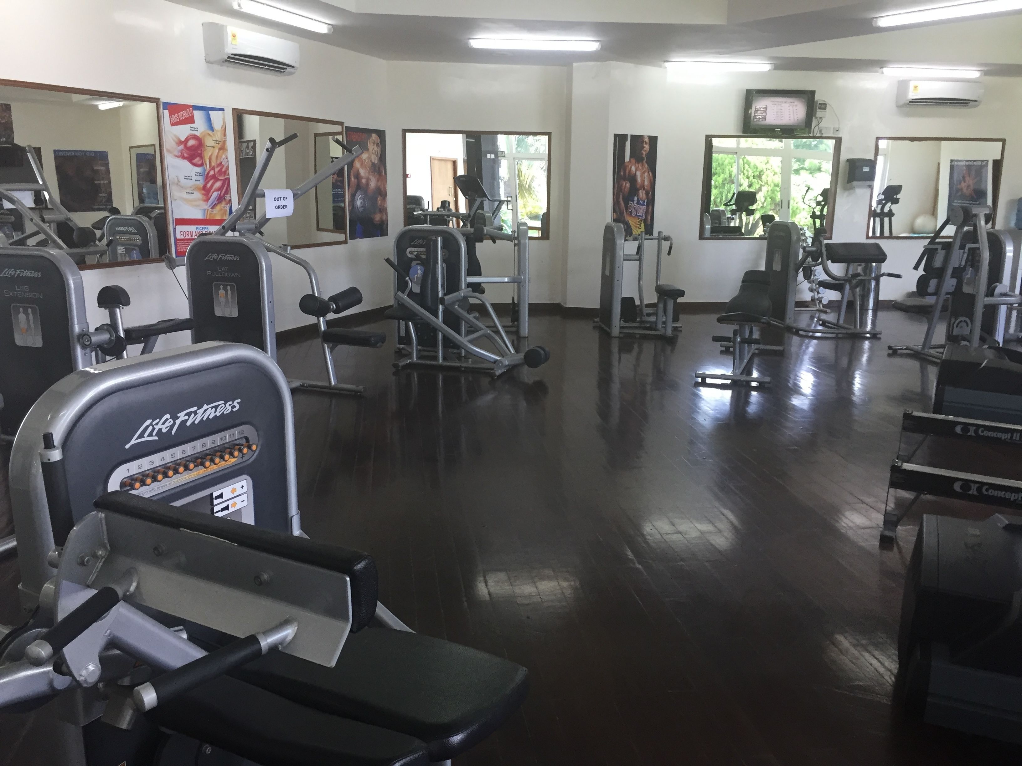 A gym with various exercise equipment, including treadmills, weight machines, and a rowing machine.