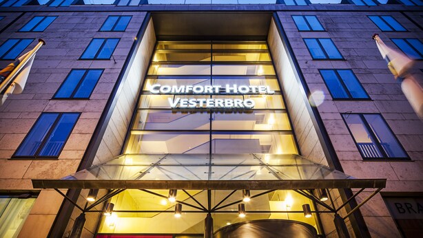 A hotel with a modern glass facade and the name "COMFORT HOTEL VESTERBRO" illuminated on the front. - Comfort Hotel Vesterbro (Copenhagen)