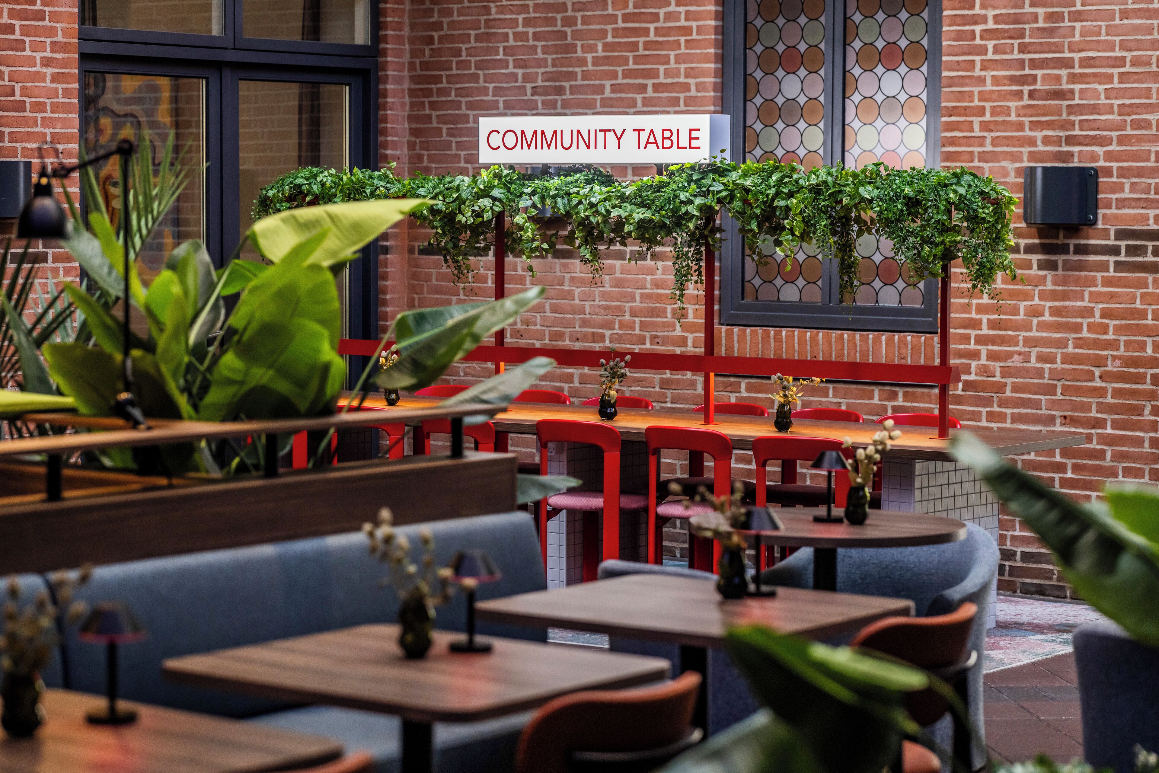 A community table area with brick walls and greenery.