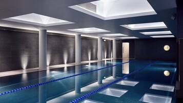 Swimmers can enjoy a refreshing dip in the pool surrounded by a minimalist design and geometric skylights.