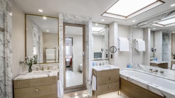 Ein modernes Badezimmer mit zwei Waschbecken, einem großen Spiegel und einer Badewanne.
