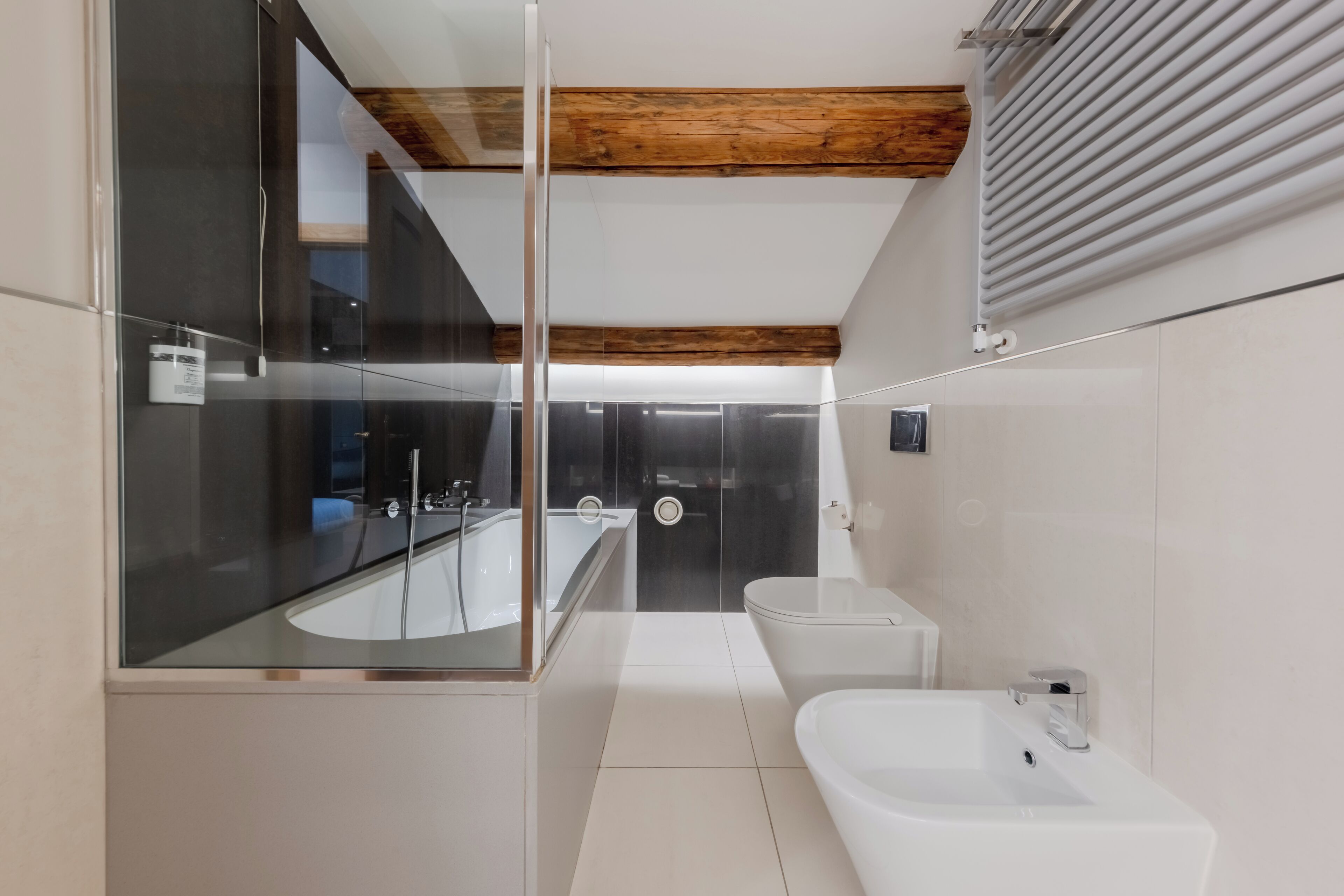 Ein modernes Badezimmer mit Duschkabine aus Glas, einem weißen Waschbecken und einer Badewanne.