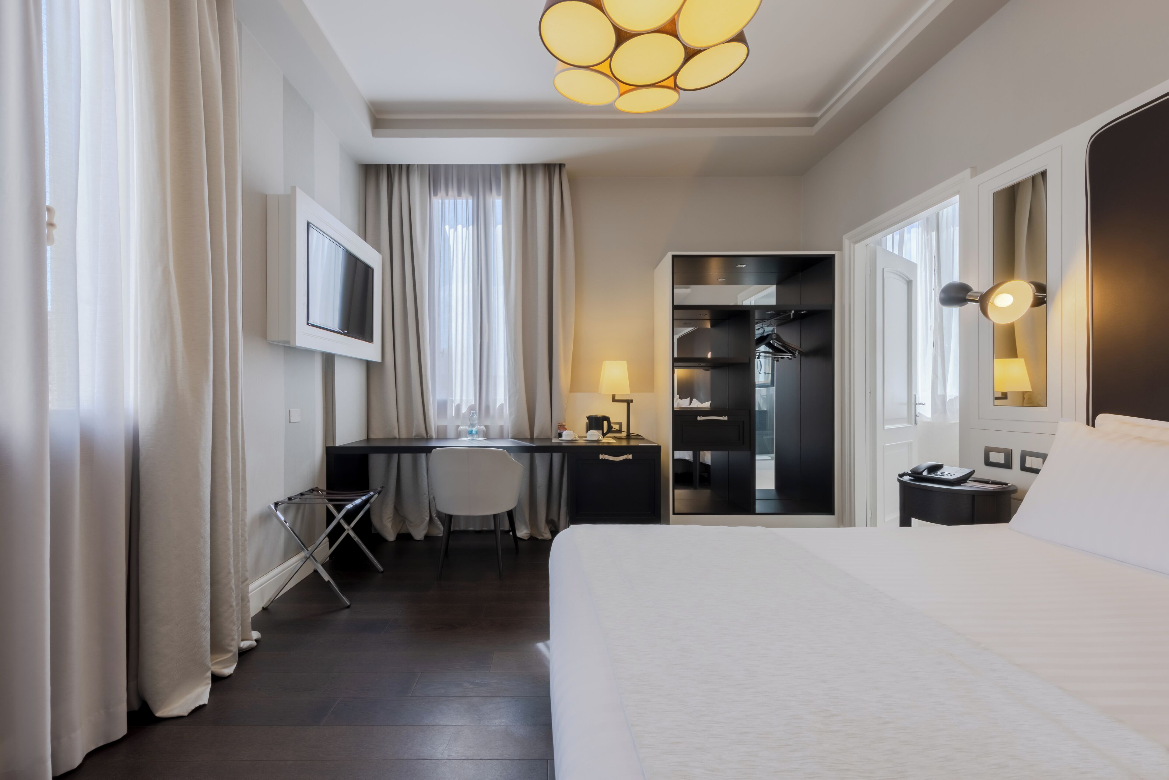 Une chambre d’hôtel équipée d’un lit, d’un bureau, d’une chaise et d’une armoire.