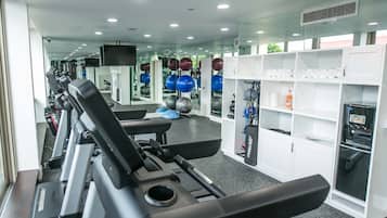 A gym with treadmills, exercise balls, and a water dispenser.
