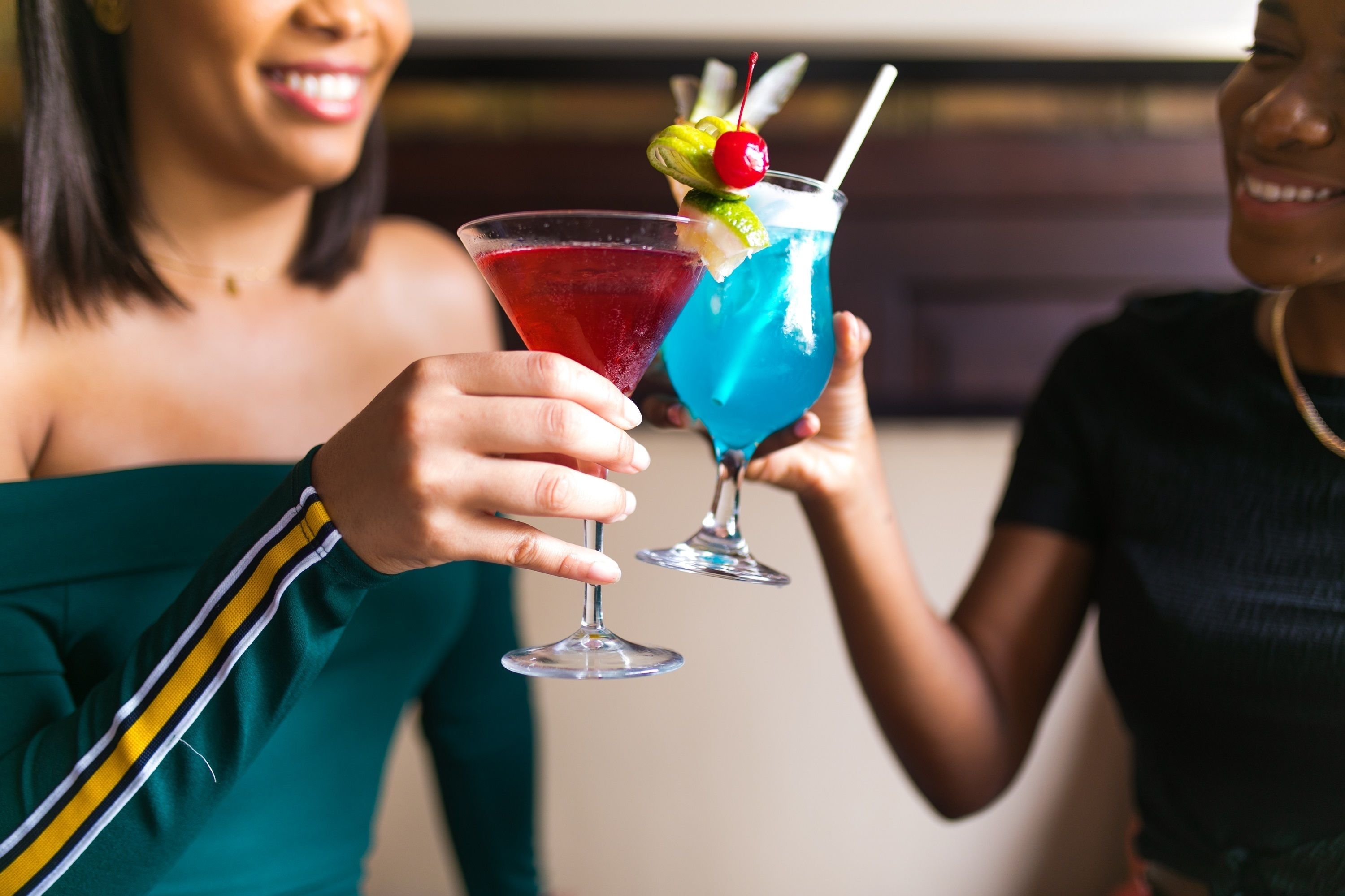 Deux personnes tenant des verres à cocktail décorés.