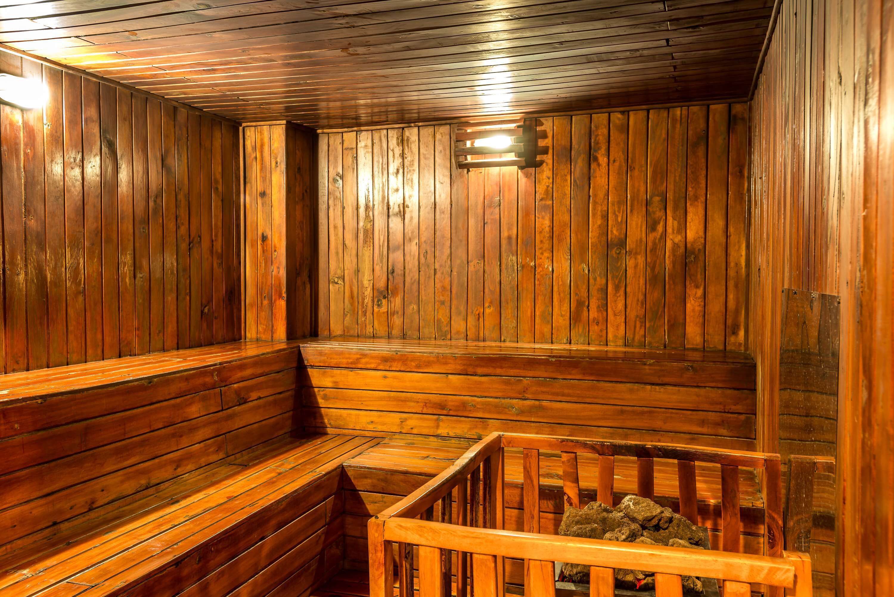 A wooden sauna with benches and a wooden bench in the foreground.